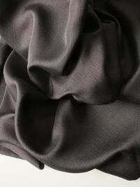 Licht glanzende verduisterende overgordijnstof in grijs met een mooie weefstructuur aan de voorzijde