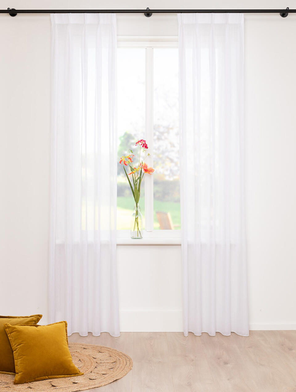 Soepelvallende naturelle vitrage met een subtiel patroon van korte lengtestreepjes (sablé).